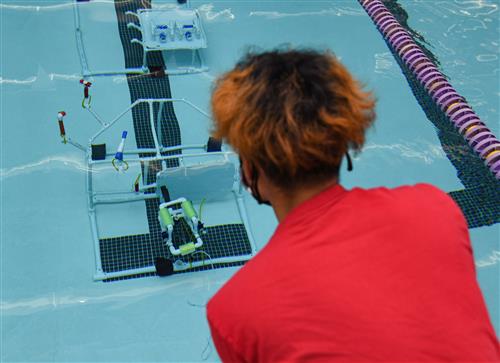student driving an underwater robot